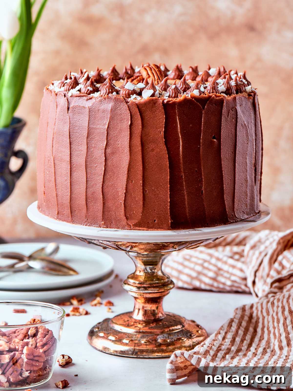 Whole German chocolate cake topped with coconut pecan frosting and stacked layers.