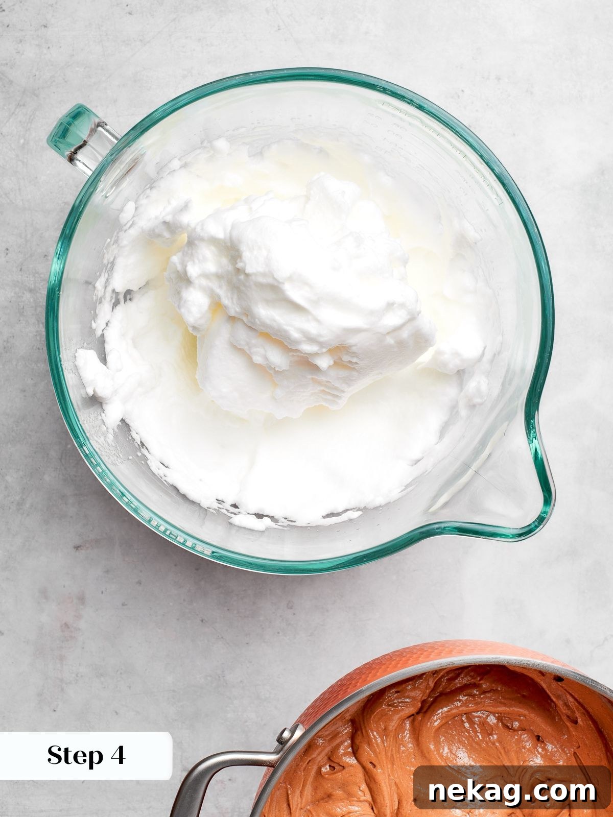 Egg whites whipped to stiff peaks in mixer bowl for cake batter.