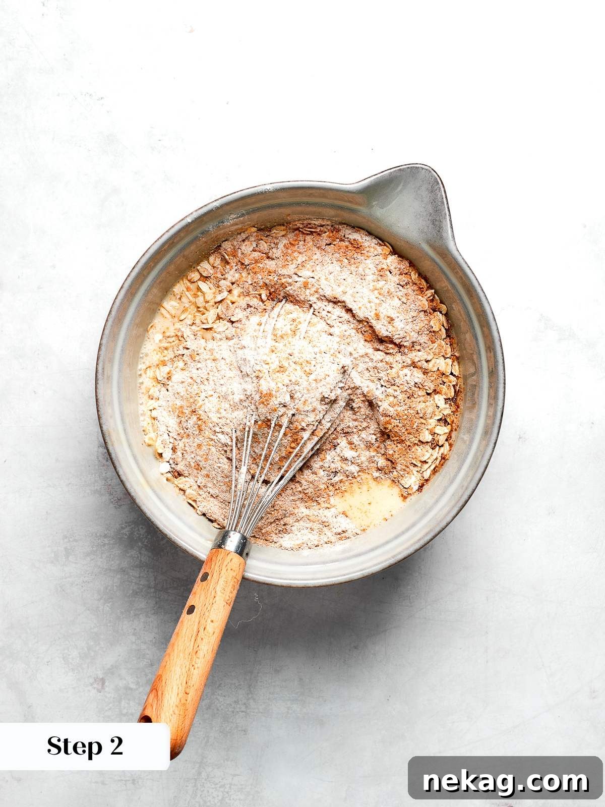 Dry ingredients whisked together including whole wheat flour oats flax and spices.