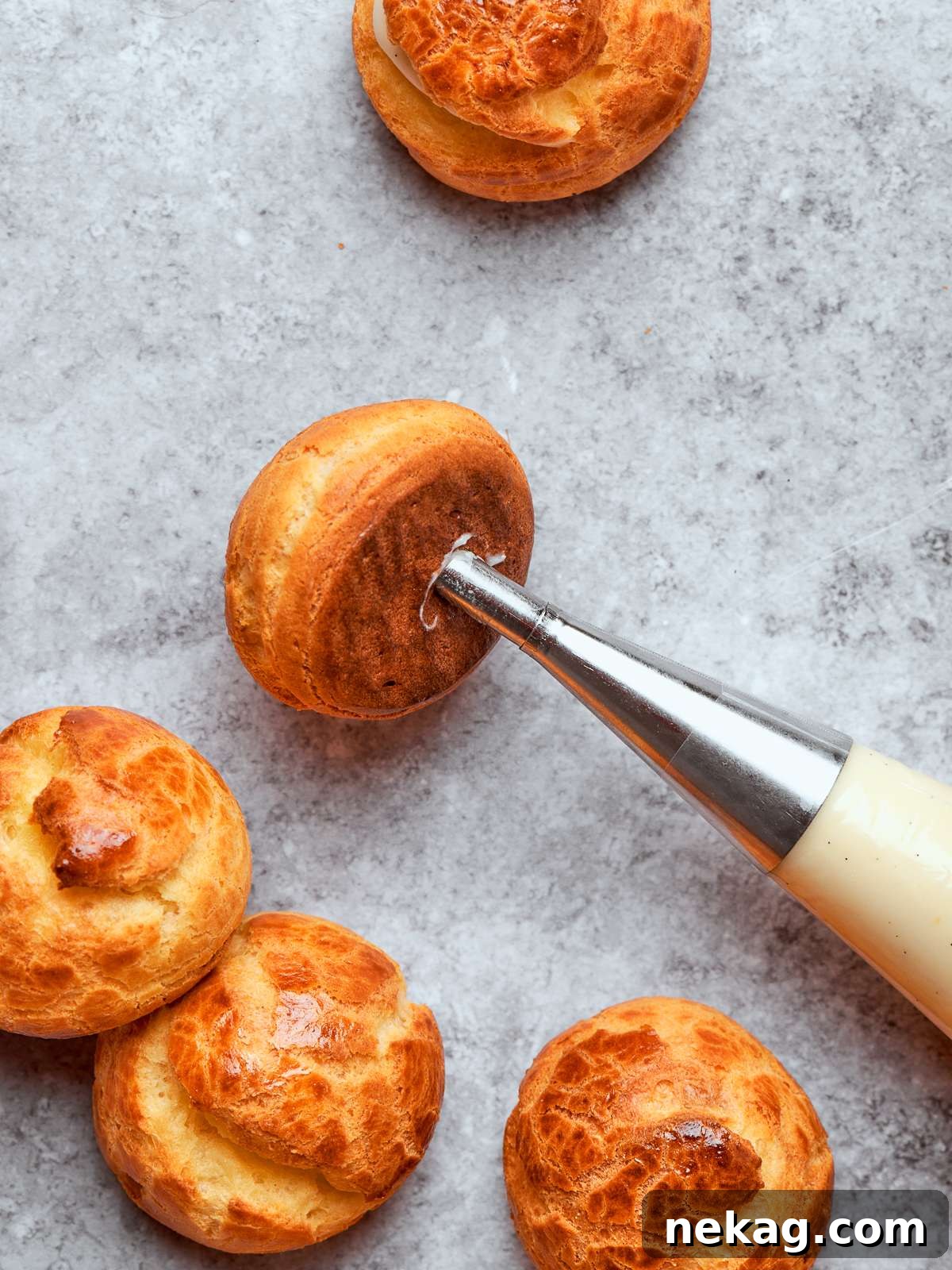 Sweet Puffs of Delight 33 Piping bag filling cream puff shells with silky crème légère through small openings.