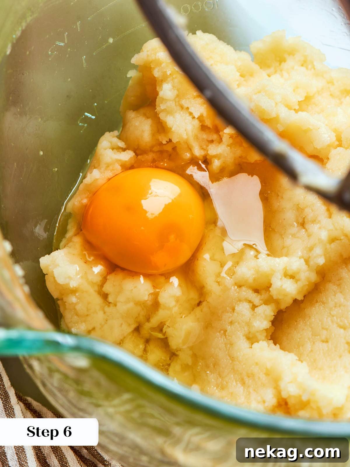 adding eggs to choux paste in mixer.