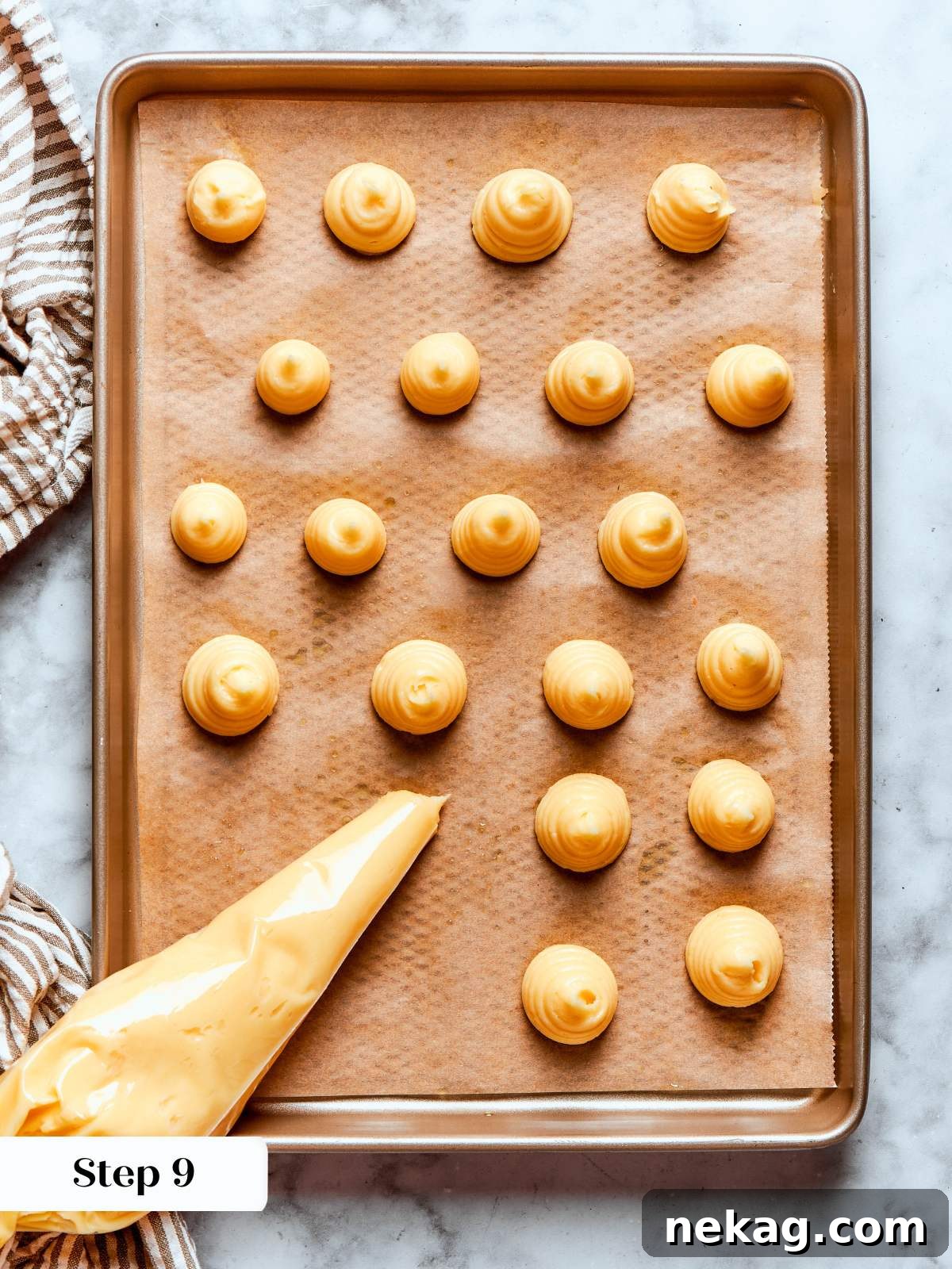 piped choux pastry rounds on brown parchment.