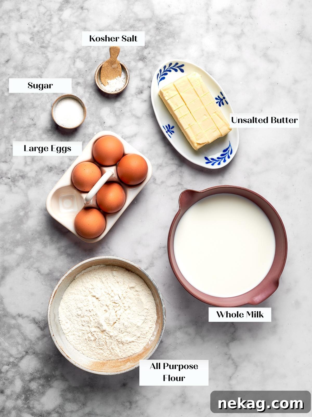 Measured ingredients arranged on countertop including butter, flour, eggs, milk, salt, and sugar.