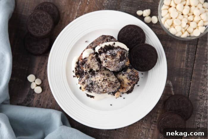 Top view of Oreo monkey bread pull apart on plate with cream cheese frosting and Oreo cookies.