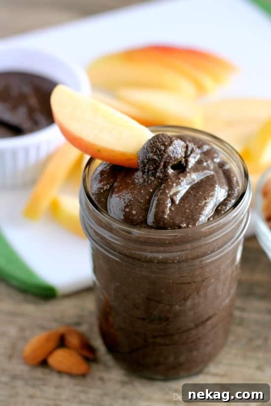 Jar of dark chocolate honey almond butter with a spoon