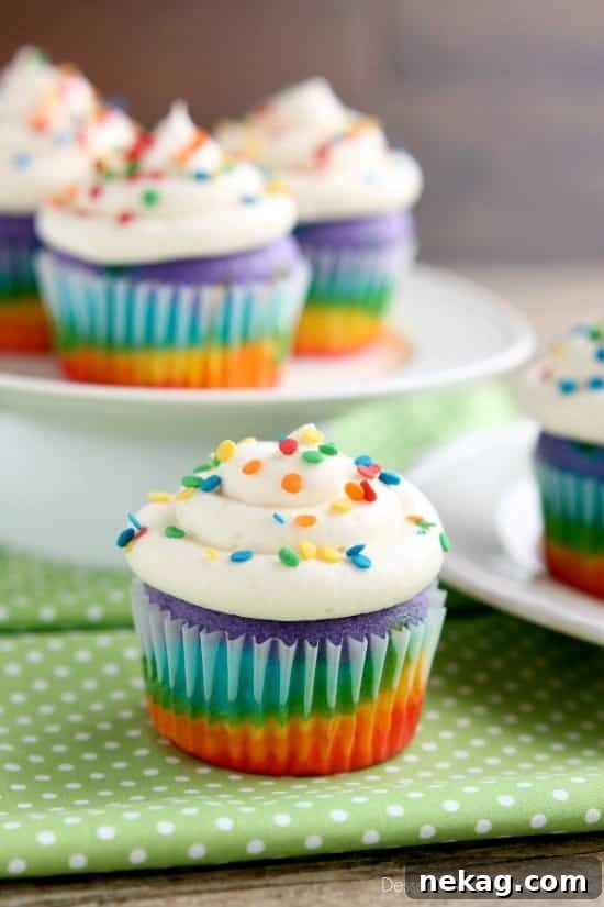 How to Make Colorful Rainbow Cupcakes (With Video Tutorial) 4 Sliced rainbow cupcake showing layers