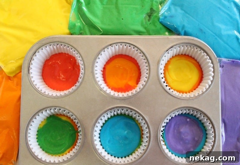 How to Make Colorful Rainbow Cupcakes (With Video Tutorial) 9 Layering colored batter in cupcake liners