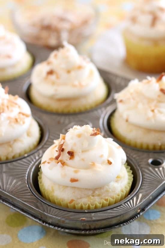 These Pina Colada Cupcakes have crushed pineapple in the cake, and coconut & rum extracts in the frosting, for a frozen drink inspired tropical dessert!
