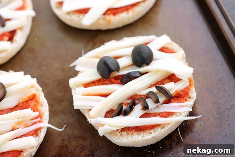 Mini Mummy Pizza Bites: Spooky Halloween Appetizer Recipe 5 Mini Mummy Pizzas are a fun and easy food the kids can make for Halloween!