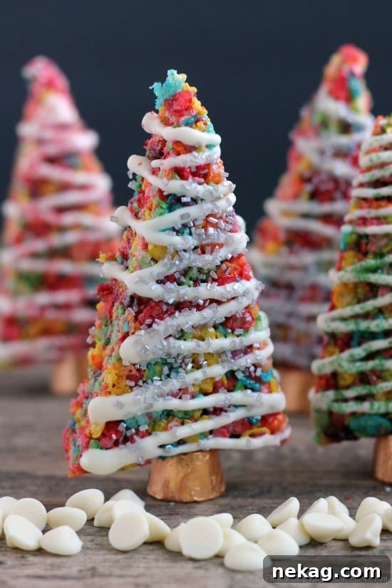 Krispie Treat Christmas Tree Recipe for Festive Holiday Treats 2 Fruity Pebbles cereal lights up these festive Krispie Treat Christmas Trees that are easy and fun to make for the holidays!