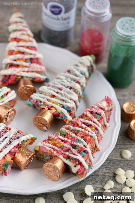 Krispie Treat Christmas Tree Recipe for Festive Holiday Treats 3 Fruity Pebbles cereal lights up these festive Krispie Treat Christmas Trees that are easy and fun to make for the holidays!