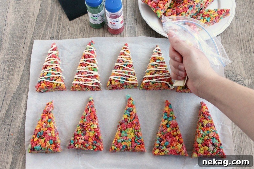 Krispie Treat Christmas Tree Recipe for Festive Holiday Treats 5 Fruity Pebbles cereal lights up these festive Krispie Treat Christmas Trees that are easy and fun to make for the holidays!