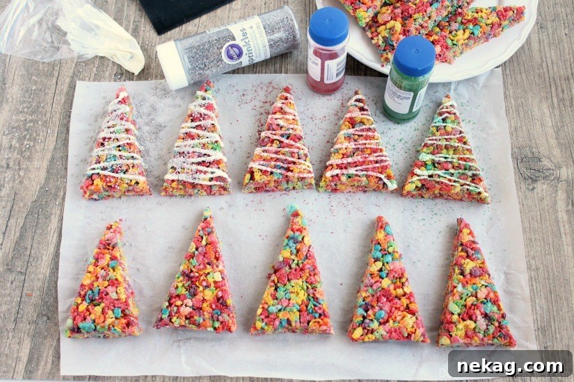 Krispie Treat Christmas Tree Recipe for Festive Holiday Treats 6 Fruity Pebbles cereal lights up these festive Krispie Treat Christmas Trees that are easy and fun to make for the holidays!