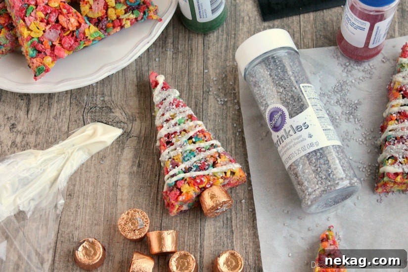 Krispie Treat Christmas Tree Recipe for Festive Holiday Treats 7 Fruity Pebbles cereal lights up these festive Krispie Treat Christmas Trees that are easy and fun to make for the holidays!