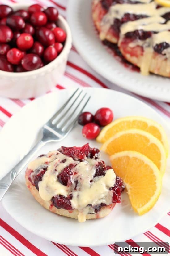 Frozen orange rolls are baked atop fresh cranberry sauce, inverted onto a dish, and drizzled with a delicious orange cream cheese glaze for a Christmas breakfast worth sharing with family and friends.