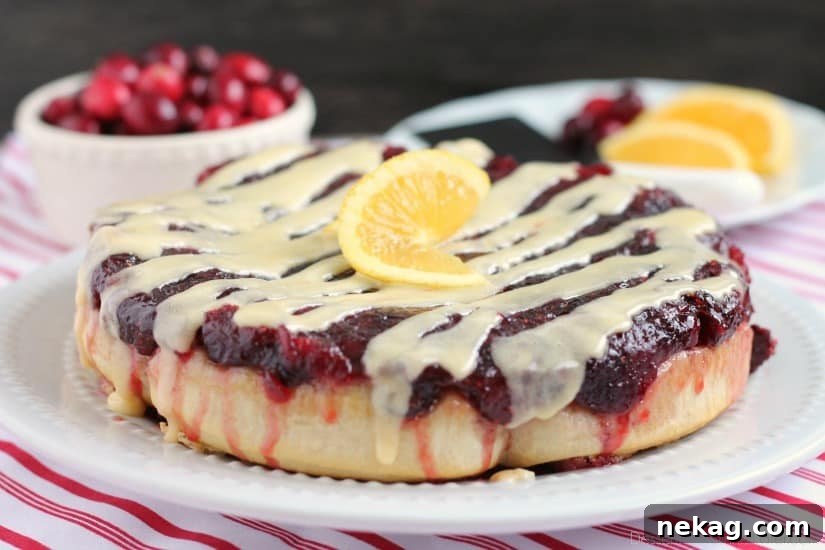 Frozen orange rolls are baked atop fresh cranberry sauce, inverted onto a dish, and drizzled with a delicious orange cream cheese glaze for a Christmas breakfast worth sharing with family and friends.