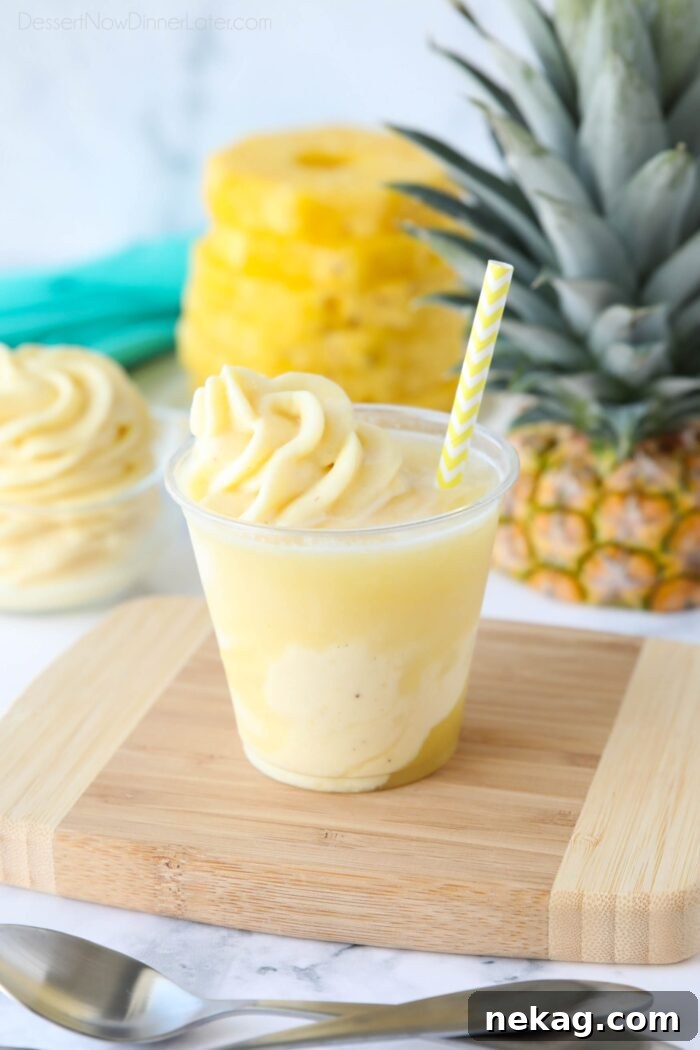 Creamy Pineapple Whip Recipe — Homemade Tropical Dessert 3 Pineapple Float - Swirled pineapple ice cream and pineapple juice in a cup with a straw.