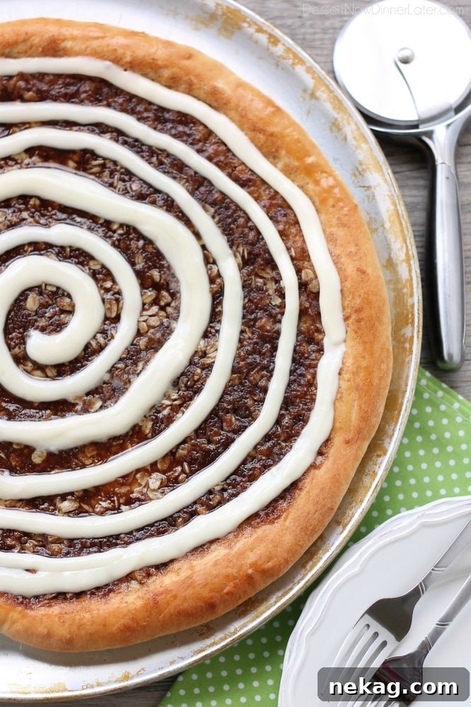 This Cinnamon Roll Dessert Pizza is an amazing copycat version of Papa Murphy's Cinnamon Wheel, with brown sugar, cinnamon, and oats, topped with a tangy cream cheese icing.