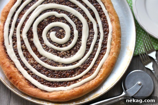 This Cinnamon Roll Dessert Pizza is an amazing copycat version of Papa Murphy's Cinnamon Wheel, with brown sugar, cinnamon, and oats, topped with a tangy cream cheese icing.