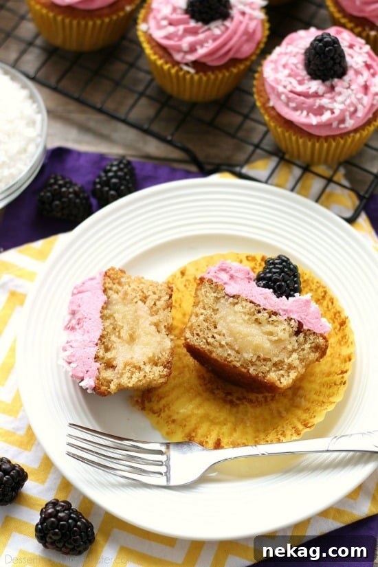 Blackberry Piña Colada Cupcakes - Moist coconut cupcakes with a sweet pineapple and rum filling topped with fresh blackberry frosting. A delicious drink inspired cupcake with a twist! (Cupcake Battles WINNER!)