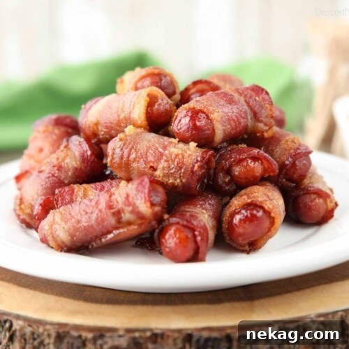 Pile of bacon wrapped smokies on a plate.