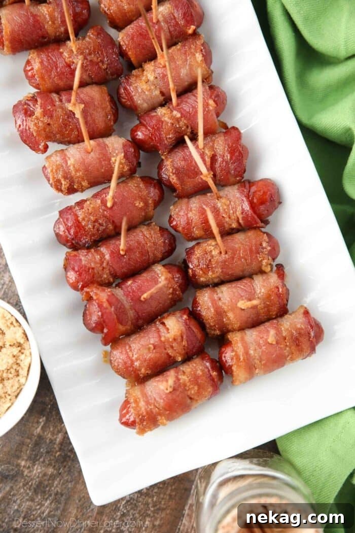 Platter of bacon wrapped cocktail weenies with toothpicks inserted.