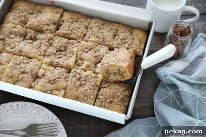 Moist Sour Cream Coffee Cake Recipe with Cinnamon Streusel 10 Top view of sour cream coffee cake in a 9x13 pan with a spatula underneath one slice.