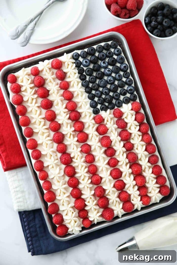 American flag brownie fruit pizza decorated with whipped cream cheese frosting, blueberries and raspberries for the stars and stripes.