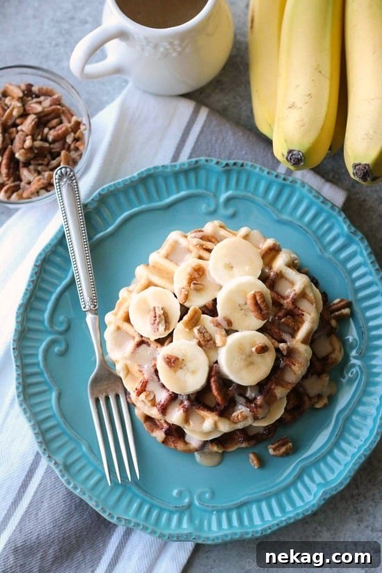 Banana Nut Cinnamon Roll Waffles Recipe — Fluffy, Caramelized Treat 3 Cinnamon Roll Waffles are topped with freshly sliced bananas, crunchy nuts, and a maple cream cheese drizzle.