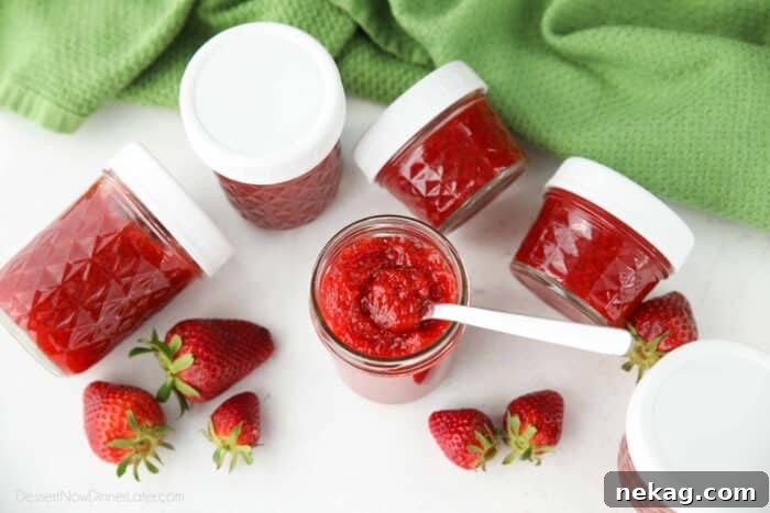 Low-Sugar Strawberry Freezer Jam Recipe with Video Tutorial 5 Top view of low-sugar strawberry freezer jam with a spoon inside.