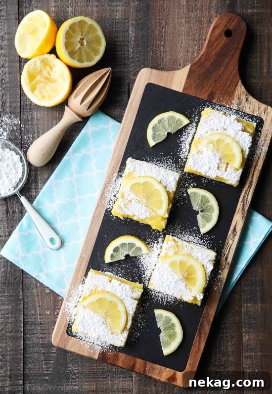 Zesty Lemon Bars Recipe: Tangy Shortbread Squares 3 Slices of lemon bars on a board with powdered sugar and lemon slices on top.