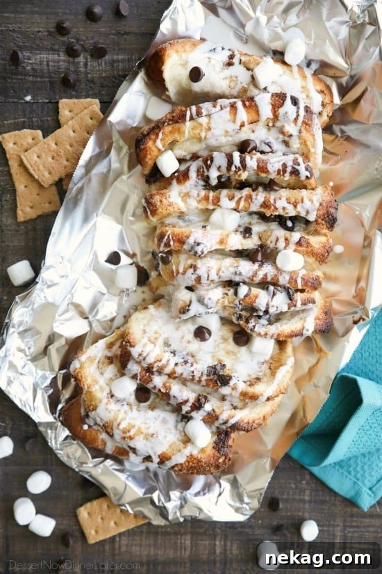 S'mores Pull Apart Bread is loaded with graham cracker crumbs, marshmallows, and chocolate chips, then topped off with a marshmallow glaze for a camping inspired dessert you can enjoy anytime!