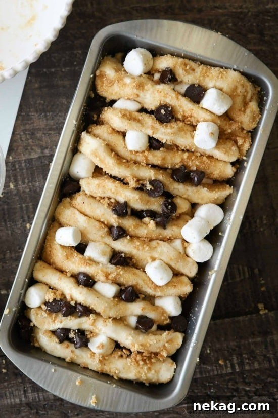 S'mores Pull Apart Bread is loaded with graham cracker crumbs, marshmallows, and chocolate chips, then topped off with a marshmallow glaze for a camping inspired dessert you can enjoy anytime!