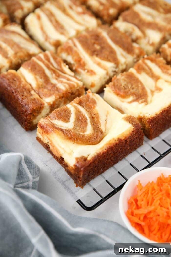 Squares of carrot cake cream cheese bars.
