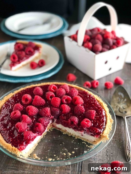 Decadent Raspberry Cream Pie Recipe with a Buttery Crust 12 Raspberry Cream Pie with a vanilla wafer crust in a pan with a couple slices taken out.