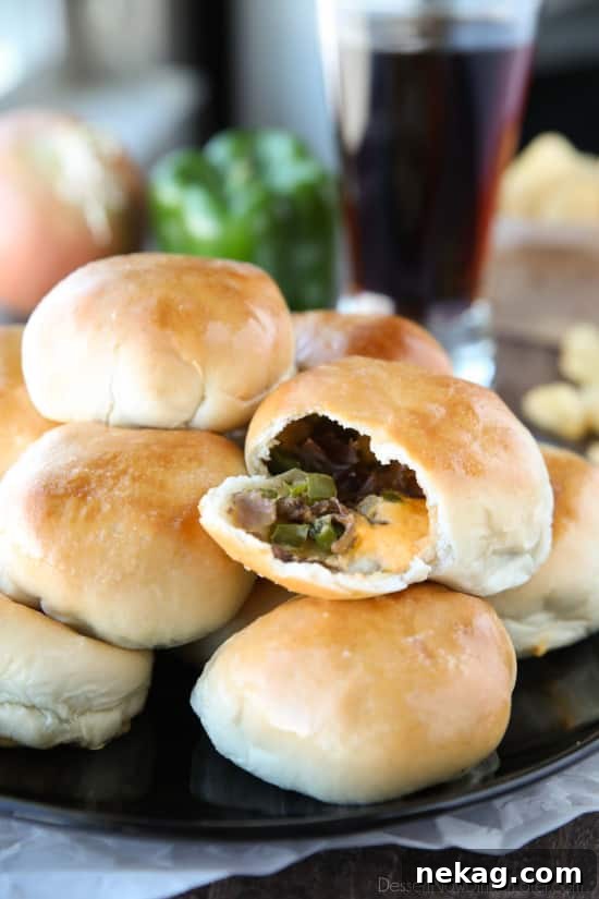 Philly Cheesesteak Bombs: Loaded Steak, Cheese & Onion Bites 2 Philly Cheesesteak Bombs roll ripped open with meat, veggies and cheese showing.