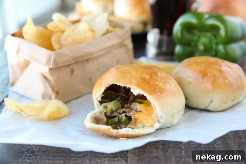 Philly Cheesesteak Bombs: Loaded Steak, Cheese & Onion Bites 3 Philly Cheesesteak Bombs roll ripped open with meat, veggies and cheese showing.