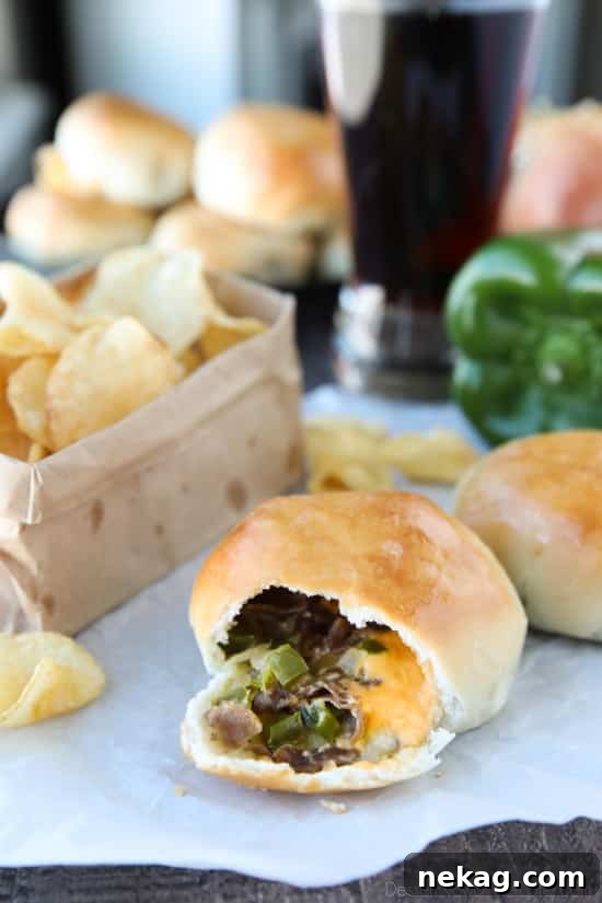 Philly Cheesesteak Bombs: Loaded Steak, Cheese & Onion Bites 4 Philly Cheesesteak Bombs roll ripped open with meat, veggies and cheese showing.