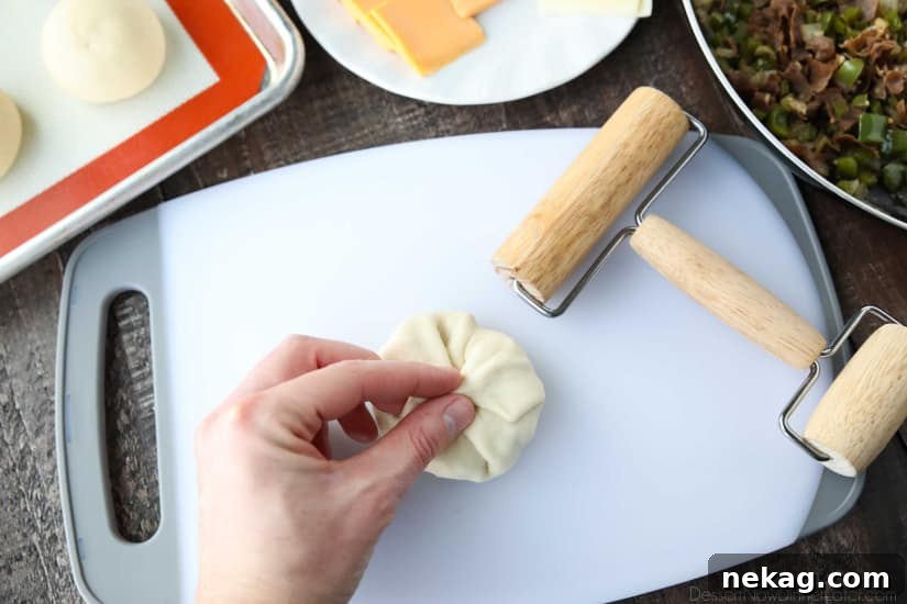 Philly Cheesesteak Bombs: Loaded Steak, Cheese & Onion Bites 8 Wrapping dough around filling and pinching shut.