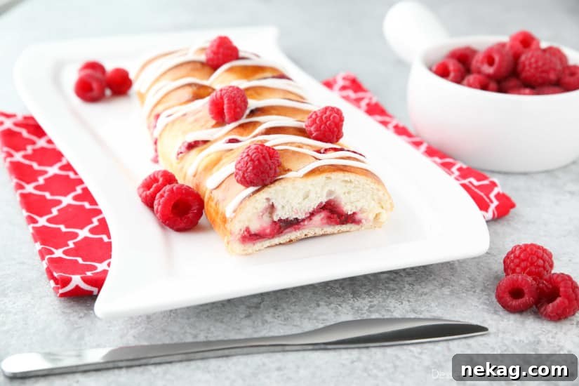 Raspberry Breakfast Braid - a quick raspberry sauce and cream cheese filling are stuffed inside this easy braided bread that's drizzled with a sweet and simple icing. A special breakfast or dessert for weekends or holidays with step-by-step pictures to help you make it.