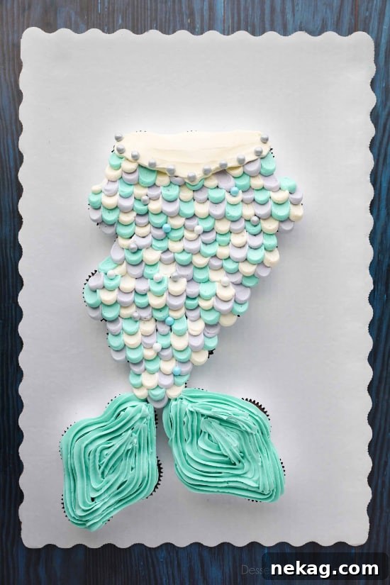 This Mermaid Tail Cupcake Cake is the perfect girls birthday cake, and this tutorial shows you exactly how to make it. Cupcakes pull apart for easy serving. (No cake to cut! Template included.)