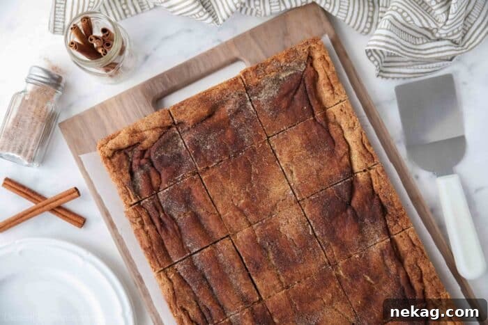 Chewy Cinnamon Bars with Brown Sugar Glaze 10 Cinnamon Bars cut into squares on a wooden cutting board.