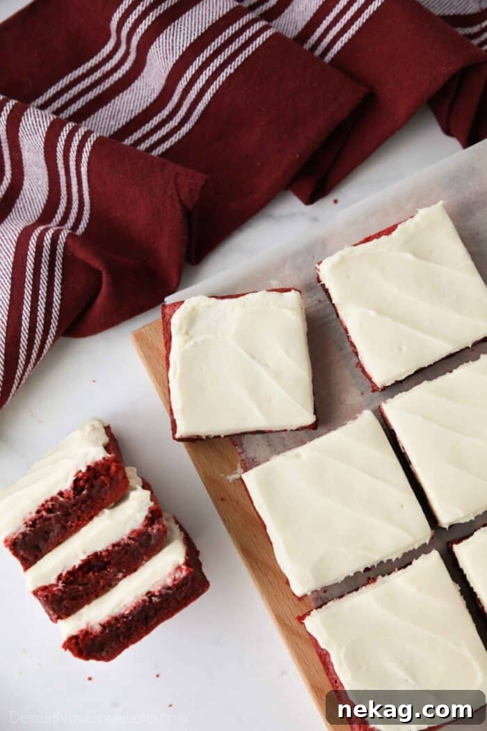Decadent Red Velvet Brownie Recipe with Cream Cheese Swirl 4 Squares of Red Velvet Brownies with cream cheese frosting on top.