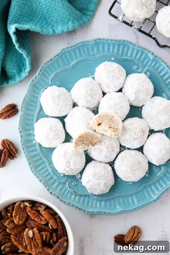 Snowball Cookies are round buttery shortbread cookies with chunks of pecans all rolled in powdered sugar. They melt in your mouth and are a delicious Christmas cookie.