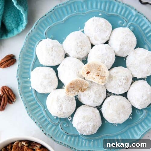 Snowball Cookies are round buttery shortbread cookies with chunks of pecans all rolled in powdered sugar. They melt in your mouth and are a delicious Christmas cookie.