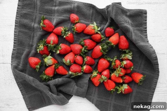 Drying strawberries completely with a towel will ensure the chocolate will stick to the fruit.