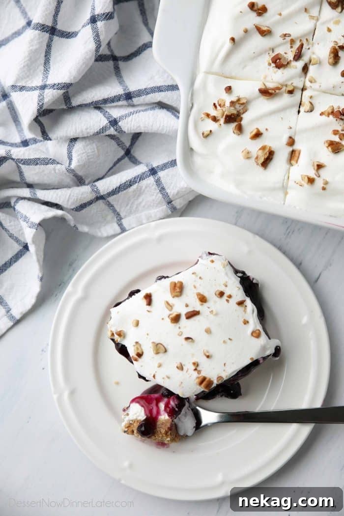 Blueberry Delight is a (nearly) no bake dessert with a graham cracker crust, topped with a cream cheese layer, blueberry pie filling, and whipped topping.