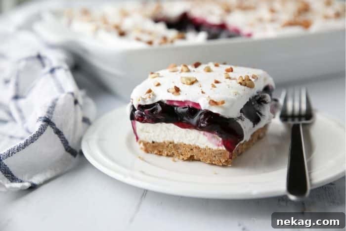 Blueberry Delight (aka Blueberry Lush) is an easy layered dessert with a graham cracker and pecan crust, no bake cheesecake, blueberry pie filling, and cool whip topping. A light, fruity, and delicious summer dessert with minimal baking.