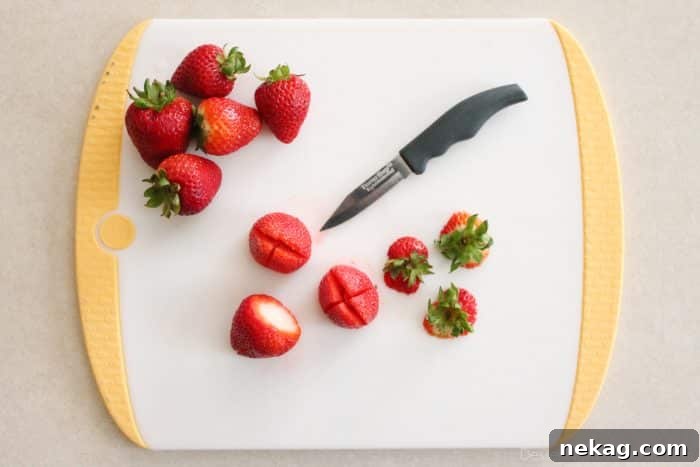 Strawberries with the leaves cut off and an "X" cut on the bottom.