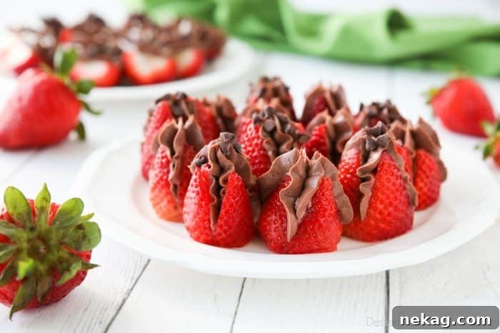 Plate of strawberries filled with no bake chocolate cheesecake filling and topped with mini chocolate chips.